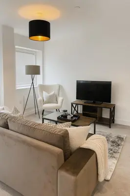 a living room with a couch and a television at Copper Suite - 2Bed Elegance - Parking in Liverpool