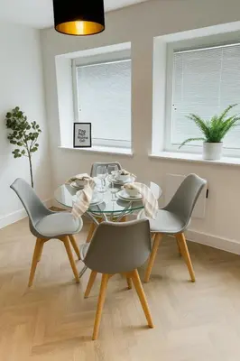 a dining room with a glass table and chairs at Copper Suite - 2Bed Elegance - Parking in Liverpool