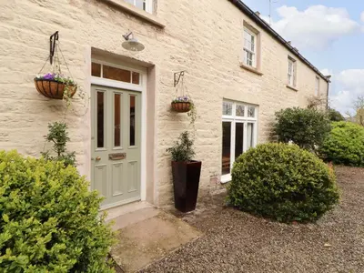 a house with two flower baskets on the door at 1 The Green in Carnforth