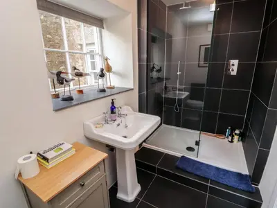 a small bathroom with a sink and a shower at 1 The Green in Carnforth