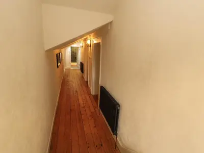 an empty hallway with a wooden floor and a white wall at 1 The Green in Carnforth