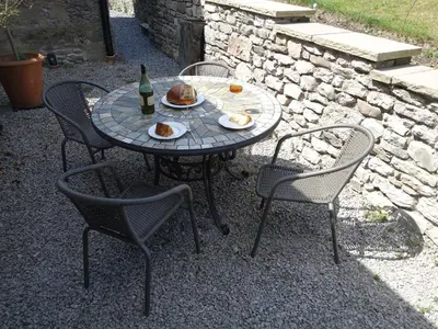 a table with two chairs and a bottle of wine and food at 1 The Green in Carnforth