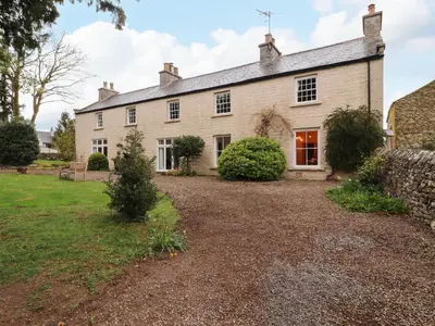 an exterior view of a large house with a yard at 1 The Green in Carnforth