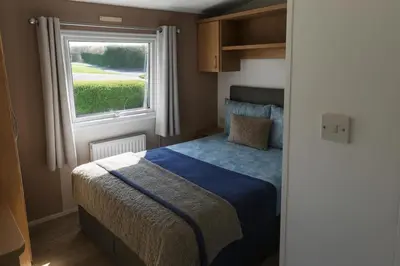 a bedroom with a bed and a window at 12a Mill View 4 Bed Static Caravan Marton Mere in Blackpool