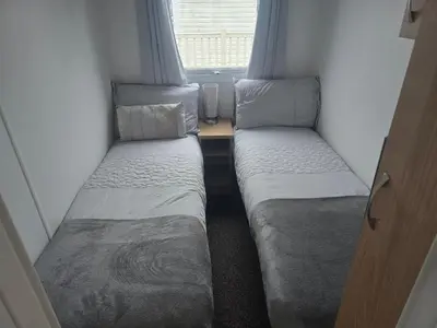 two beds in a small room with a window at 12a Mill View 4 Bed Static Caravan Marton Mere in Blackpool