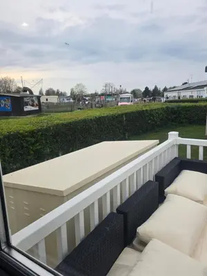 a balcony with a table and chairs and a field at 12a Mill View 4 Bed Static Caravan Marton Mere in Blackpool