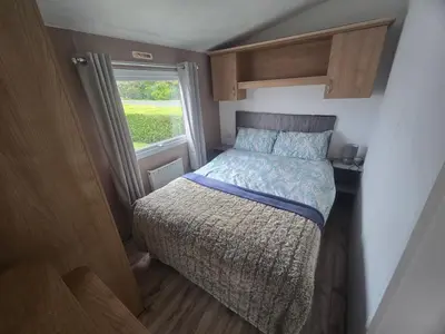 a small bed in a small room with a window at 12a Mill View 4 Bed Static Caravan Marton Mere in Blackpool