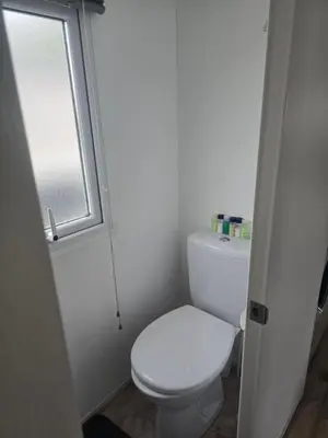 a bathroom with a white toilet and a window at 12a Mill View 4 Bed Static Caravan Marton Mere in Blackpool