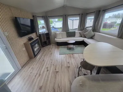 a living room with a couch and a tv and a table at 12a Mill View 4 Bed Static Caravan Marton Mere in Blackpool