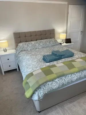 a bedroom with a bed with two night stands and two lamps at Norwood Manor in Southport