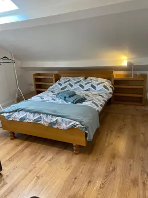 a bed in a bedroom with a wooden floor at Norwood Manor in Southport