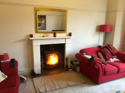 a living room with two red couches and a fireplace at Norwood Manor in Southport