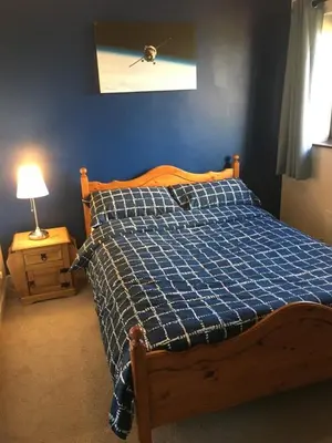 a bedroom with a bed with a blue comforter at Quiet times away from city noise, but not too far! in Skelmersdale