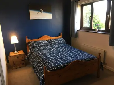 a blue bedroom with a bed and a window at Quiet times away from city noise, but not too far! in Skelmersdale