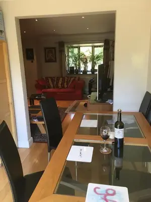 a bottle of wine sitting on a glass table in a living room at Quiet times away from city noise, but not too far! in Skelmersdale