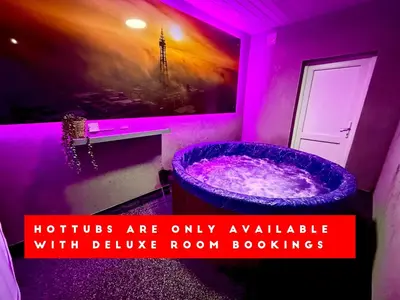a bathroom with a purple room with a tub at Hornby Hottub and Jacuzzi Suites in Blackpool