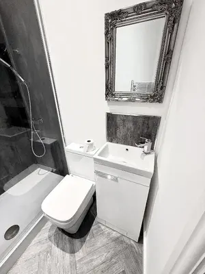a bathroom with a toilet and a sink and a mirror at Hornby Hottub and Jacuzzi Suites in Blackpool