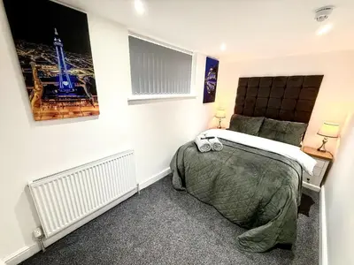 a bedroom with a bed and a picture on the wall at Hornby Hottub and Jacuzzi Suites in Blackpool