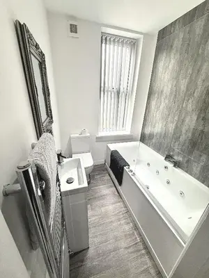 a bathroom with a tub and a toilet and a sink at Hornby Hottub and Jacuzzi Suites in Blackpool