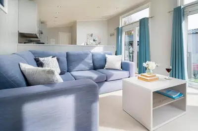 a blue couch in a living room with a table at Silverdale Lodge, HotTub, Wi-FI, Quiet & Sleeps 4 in Warton
