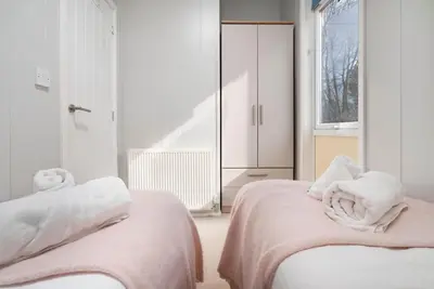 a bedroom with two beds with towels on them at Silverdale Lodge, HotTub, Wi-FI, Quiet & Sleeps 4 in Warton