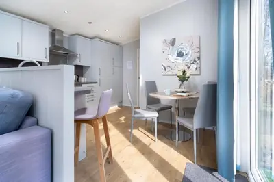 a kitchen and dining room with a table and chairs at Silverdale Lodge, HotTub, Wi-FI, Quiet & Sleeps 4 in Warton