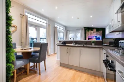 a kitchen with a table and chairs and a dining room at Silverdale Lodge, HotTub, Wi-FI, Quiet & Sleeps 4 in Warton