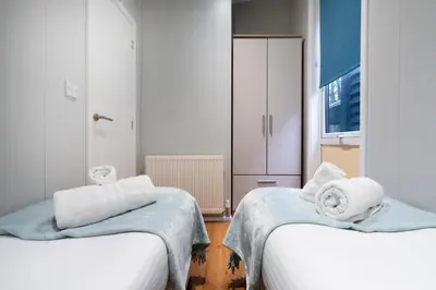 a room with two beds with towels on them at Silverdale Lodge, HotTub, Wi-FI, Quiet & Sleeps 4 in Warton