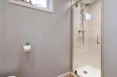 a bathroom with a shower with a glass door at Silverdale Lodge, HotTub, Wi-FI, Quiet & Sleeps 4 in Warton