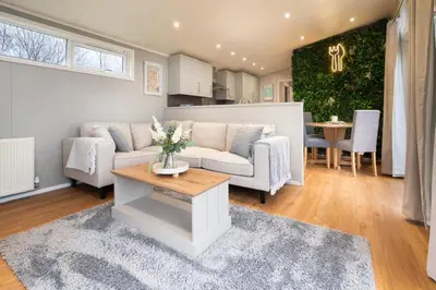 a living room with a couch and a table at Silverdale Lodge, HotTub, Wi-FI, Quiet & Sleeps 4 in Warton