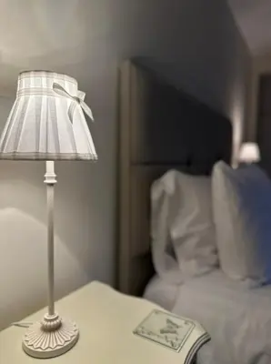 a lamp on a table next to a bed at The Forge, Newly Converted Barn in Carnforth