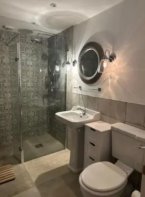 a bathroom with a shower and a toilet and a sink at The Forge, Newly Converted Barn in Carnforth