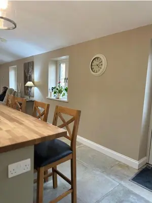 a kitchen and dining room with a clock on the wall at The Forge, Newly Converted Barn in Carnforth