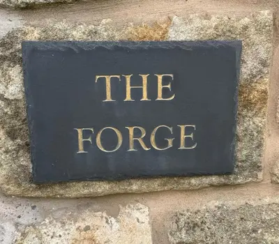 a stone sign that says the force on a stone wall at The Forge, Newly Converted Barn in Carnforth