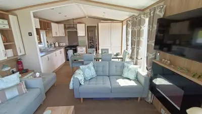a living room with a couch and a kitchen at 95C Sunset View Port Haverigg Marina Village in Millom
