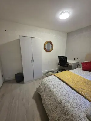 a bedroom with a bed and a cabinet and a desk at Serene room in Liverpool