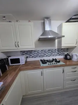 a kitchen with white cabinets and a stove top oven at Serene room in Liverpool