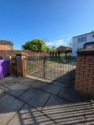 a wrought iron fence with a gate in a yard at Serene room in Liverpool