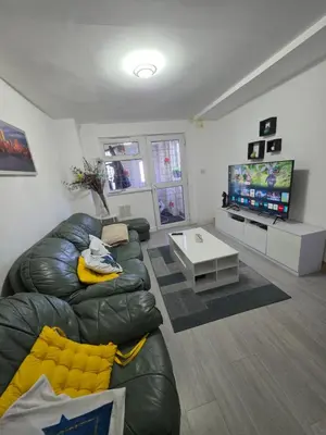 a living room with a leather couch and a flat screen tv at Serene room in Liverpool