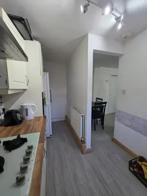 a kitchen with a stove and a table in a room at Serene room in Liverpool