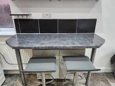 a kitchen counter with two chairs and a counter top at Newly Refurbished 3 Bedroom House with Lovely Garden in Bolton