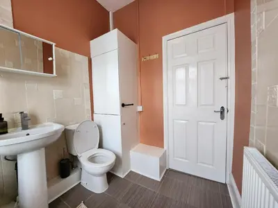 a bathroom with a white toilet and a sink at Newly Refurbished 3 Bedroom House with Lovely Garden in Bolton