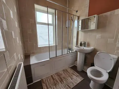 a bathroom with a toilet and a sink and a shower at Newly Refurbished 3 Bedroom House with Lovely Garden in Bolton