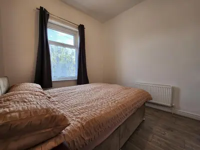 a bedroom with a bed and a window at Newly Refurbished 3 Bedroom House with Lovely Garden in Bolton