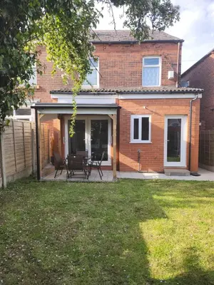 a extension to a brick house with a patio at Newly Refurbished 3 Bedroom House with Lovely Garden in Bolton