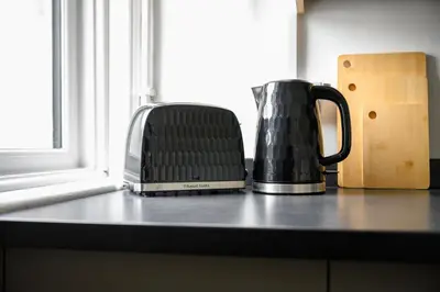 two coffee pots sitting on a counter next to a window at Free Parking Stunning 3Bedroom Home In Wigan in Wigan
