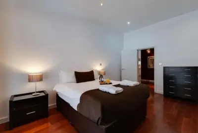 a bedroom with a large bed and a dresser at 3 Bedroom Apartment Central Liverpool in Liverpool