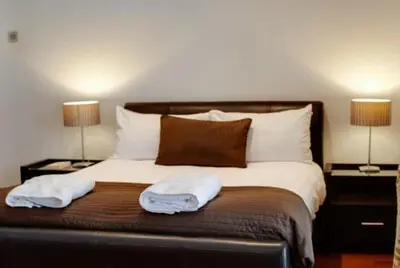 a bedroom with a bed with two lamps on both sides at 3 Bedroom Apartment Central Liverpool in Liverpool