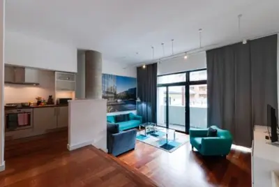 a living room with blue furniture and a kitchen at 3 Bedroom Apartment Central Liverpool in Liverpool