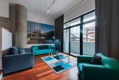 a living room with blue couches and a glass table at 3 Bedroom Apartment Central Liverpool in Liverpool